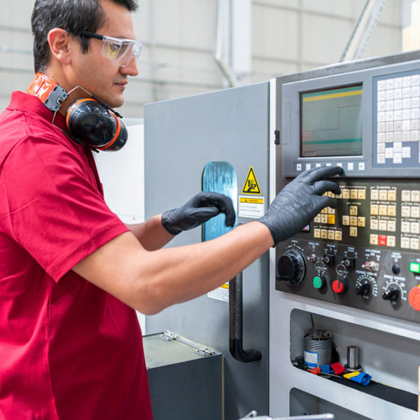 worker in a factory pressing a button